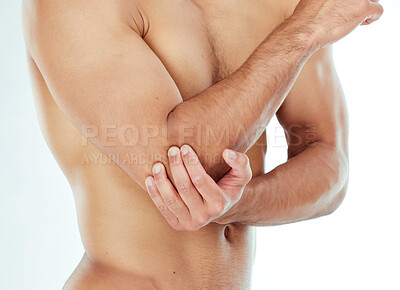 Buy stock photo Shot of a man clutching his elbow in pain against a studio background