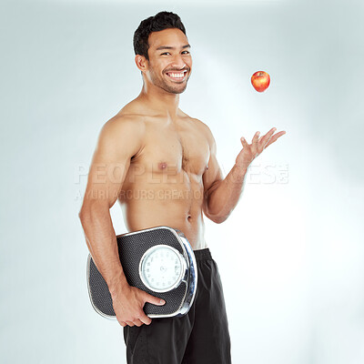 Buy stock photo Wellness, scale and happy man portrait with apple throw in studio for health, diet or Weight loss motivation on white background. Nutrition, detox or face of Japanese model fruit, balance or progress