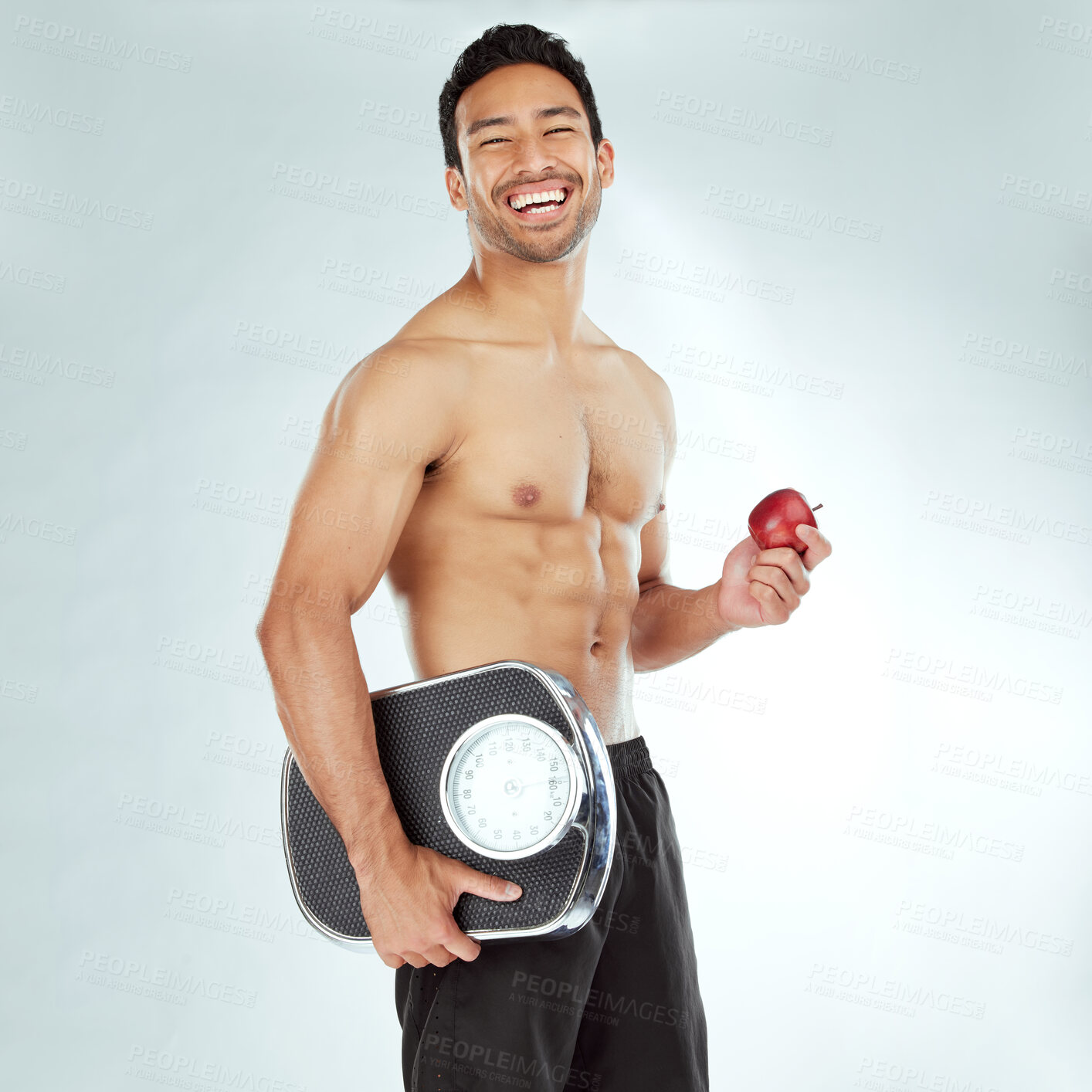 Buy stock photo Health, scale and portrait of fitness man with apple in studio for weight loss, diet or detox on white background. Nutrition, balance or face of wellness model smile for superfoods, fruit or progress