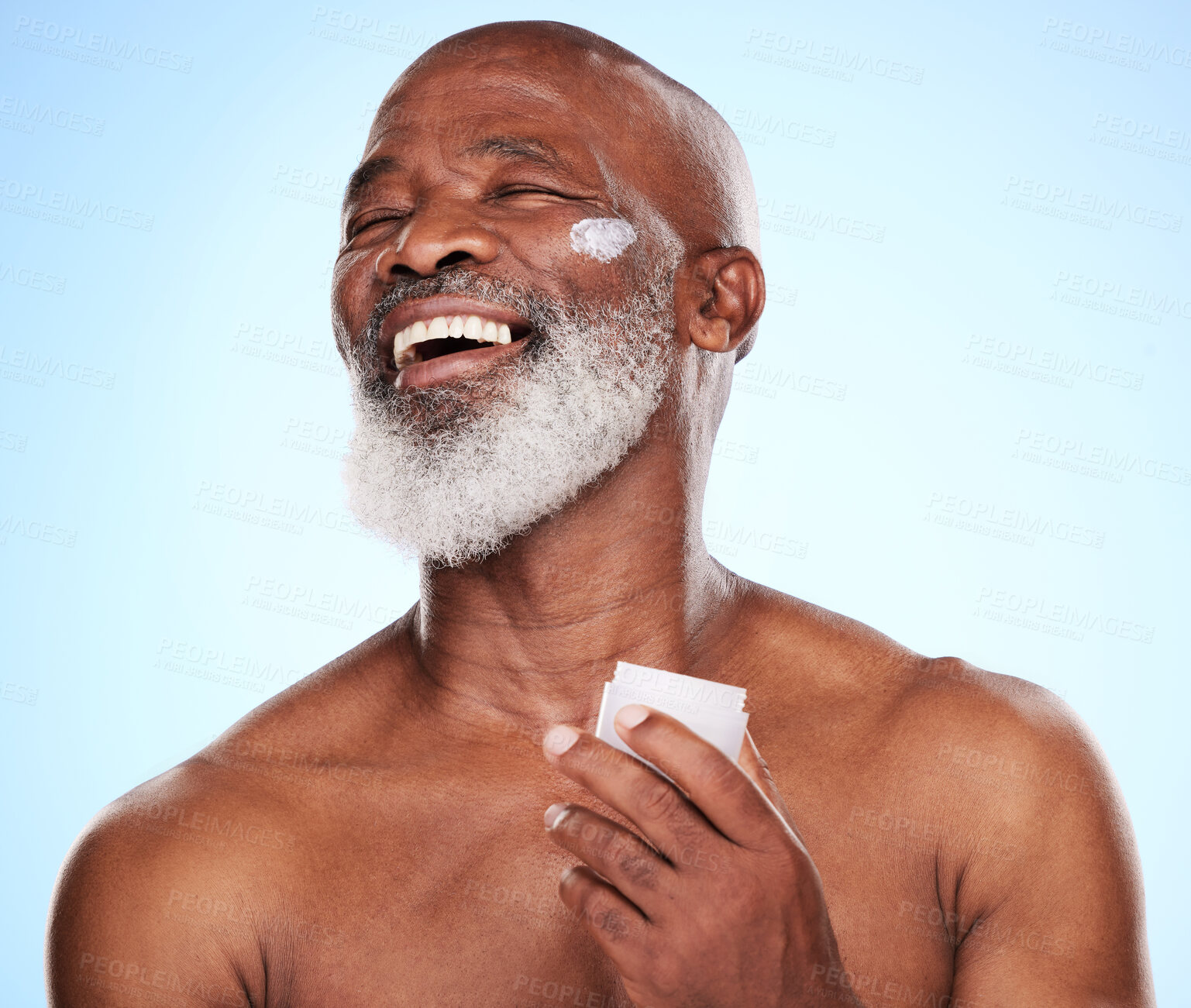 Buy stock photo Skincare, cream and happy African man in studio for dermatology, wellness and treatment. Laugh, black male person and healthy glow, shine and moisturizer by blue background for retirement or morning