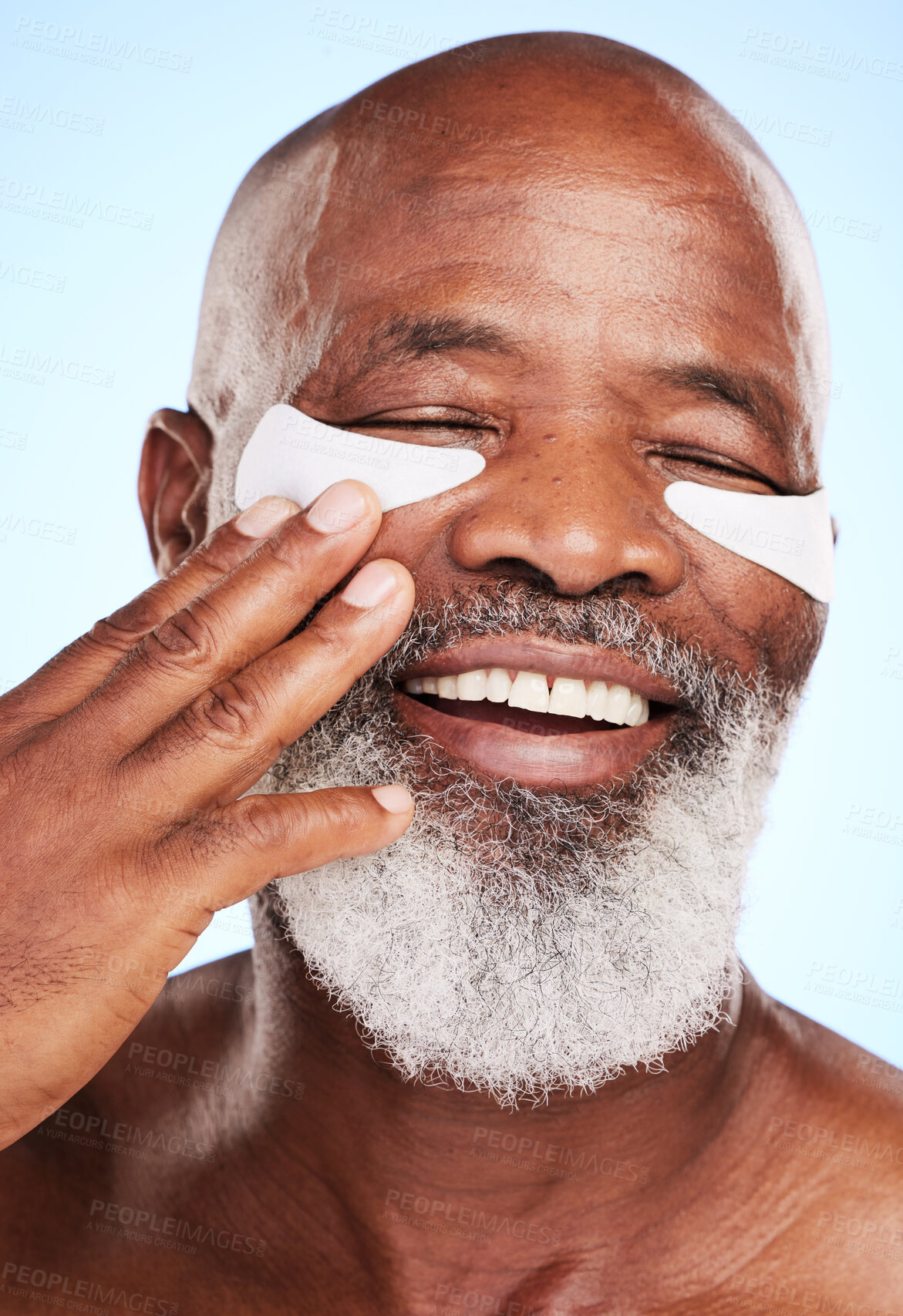 Buy stock photo Black man, smile and skincare in studio with eye mask for cleaning, hydration and skin moisturizer. Mature person, face and dermatology on blue background with beauty patch for puffiness or treatment