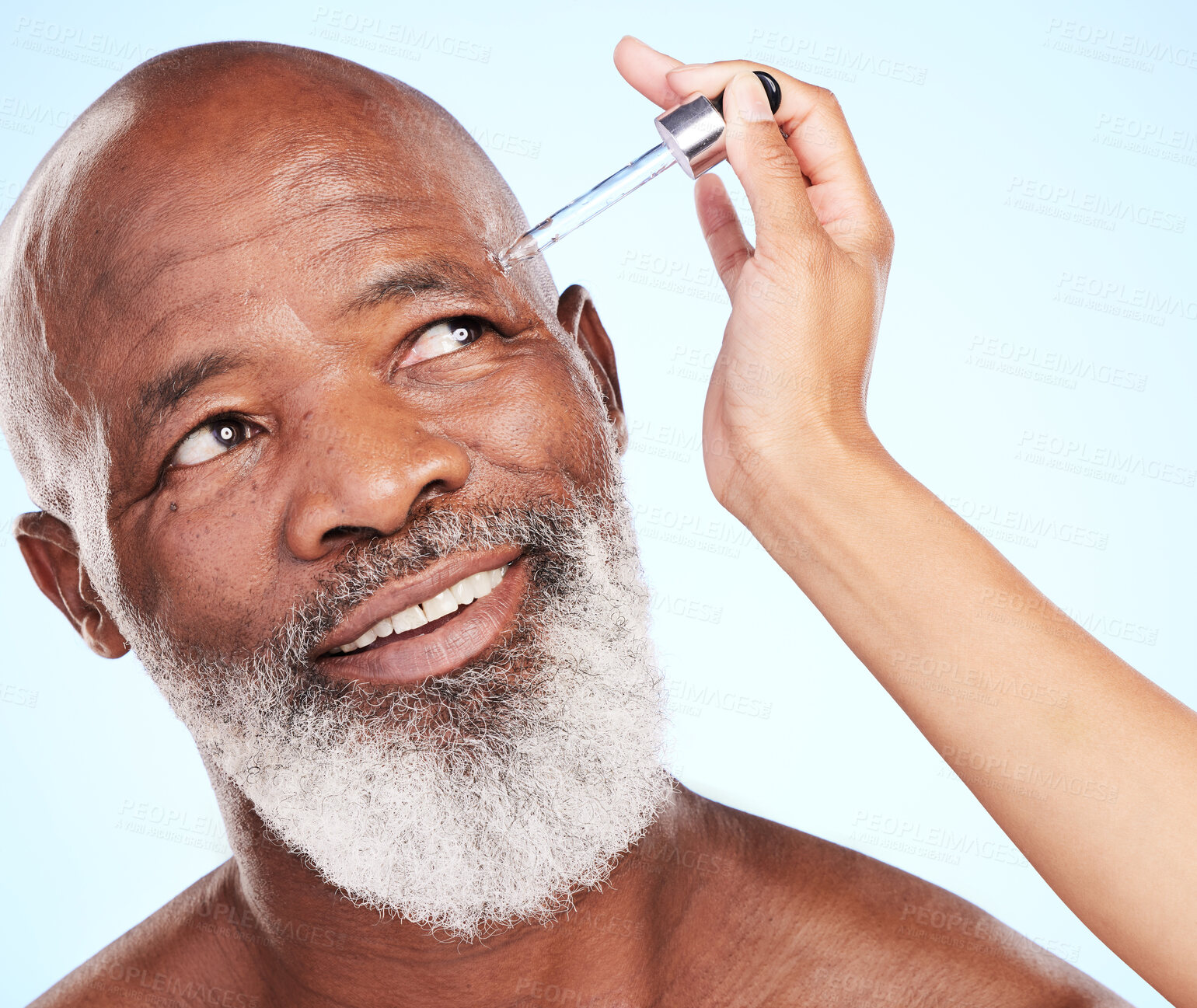 Buy stock photo Black man, senior skincare and serum in studio for spa treatment, skin hydration and vitamin C. Dermatologist hand, face and elderly person on blue background for antiaging with facial oil in pipette