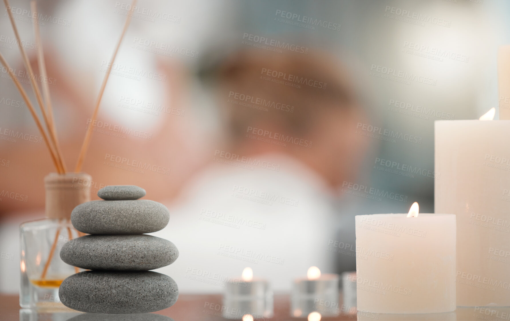 Buy stock photo Spa, candles and pile of hot stones for luxury, wellness and health treatment with zen atmosphere. Calm, beauty and bunch of warm rocks in skincare for aromatherapy for relaxing ambient at salon.