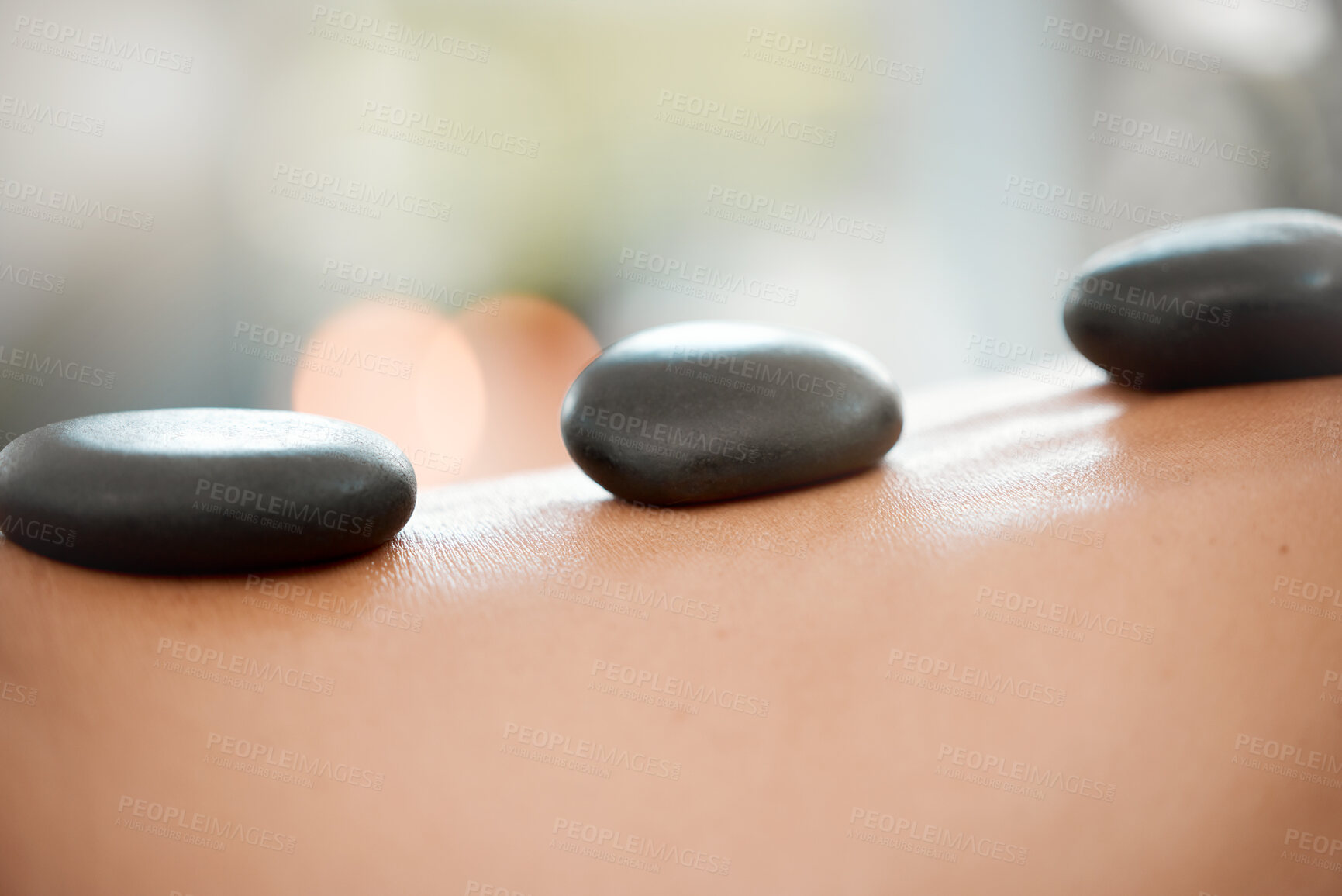 Buy stock photo Calm, person and back with hot stone massage at spa for body treatment, wellness and skincare. Resort, hospitality and client with rock for deep tissue healing, holistic and muscle health at hotel