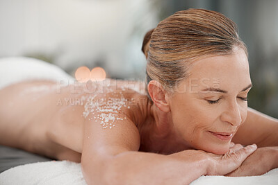 Buy stock photo Shot of a mature woman resting with exfoliating salt on her back at a spa