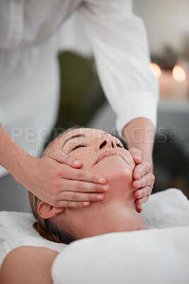Buy stock photo Shot of a woman receiving a facial massage while at a spa