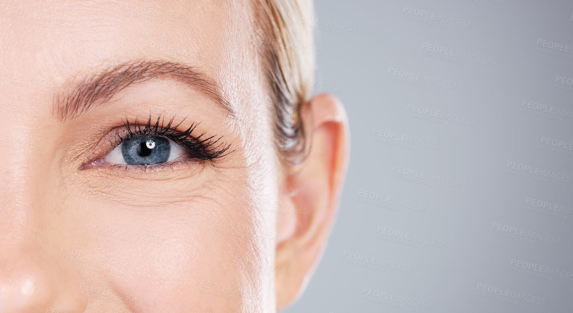 Buy stock photo Woman, portrait and makeup with blue eyes in skincare, cosmetics or optometry on a gray studio background. Closeup of female person or model with sight, eyelash or retina for mascara on mockup space