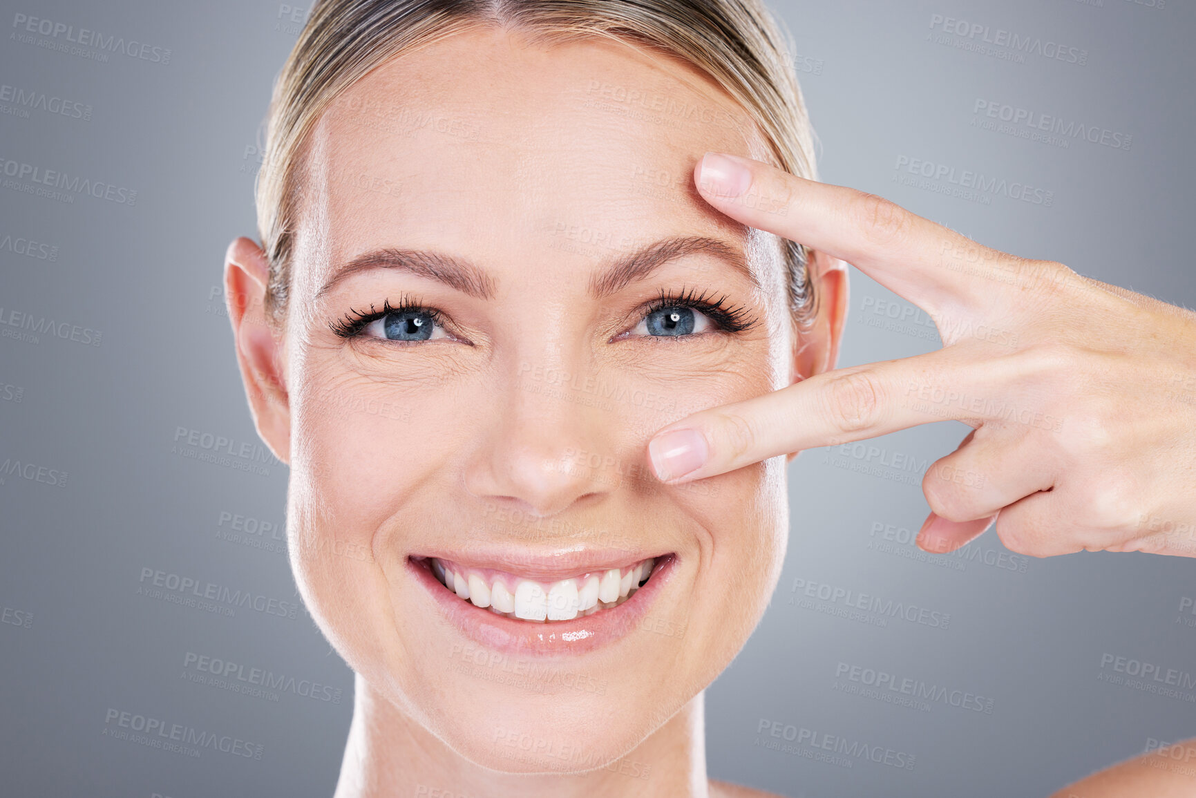 Buy stock photo Peace sign, skincare and portrait of woman in studio for cosmetics, wellness and facial treatment. Dermatology, salon and person with hands for eyes, anti aging and natural beauty on gray background