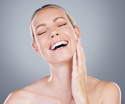 Buy stock photo Studio shot of an attractive mature woman touching her face against a grey background