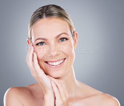Buy stock photo Studio portrait of an attractive mature woman touching her face against a grey background