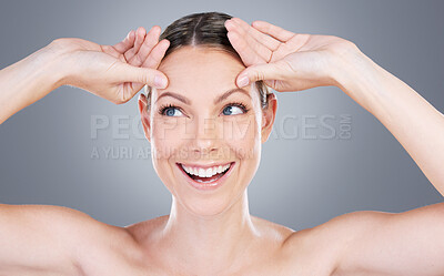 Buy stock photo Studio shot of an attractive mature woman touching her forehead against a grey background
