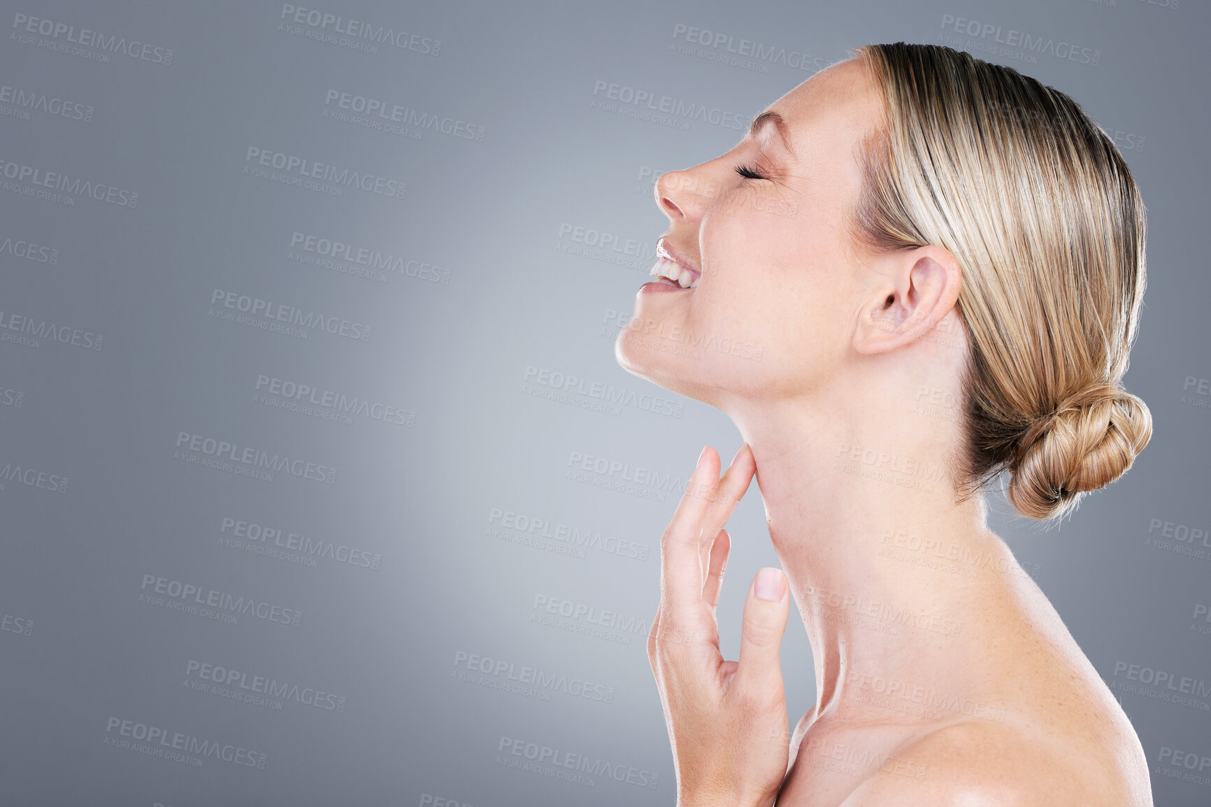 Buy stock photo Studio shot of an attractive mature woman touching her neck against a grey background