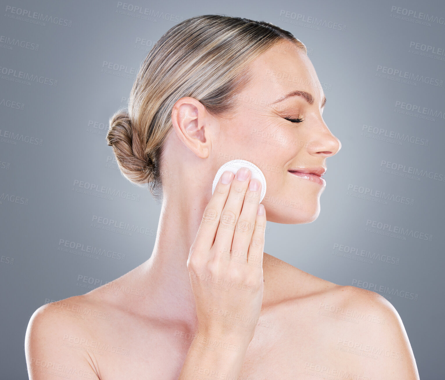 Buy stock photo Happy woman, cotton pad and cosmetics with makeup for foundation, blush or removal on a gray studio background. Female person or model with smile or patch for applying beauty or facial treatment