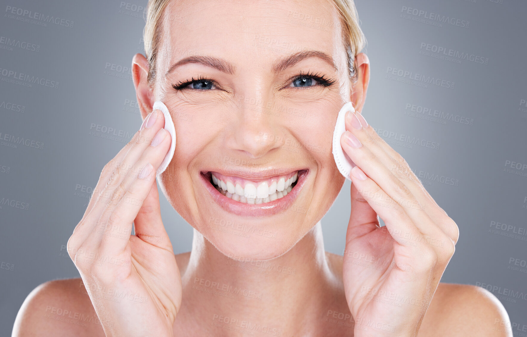 Buy stock photo Happy woman, portrait and beauty with cotton pad for skincare, cosmetics or makeup removal on a gray studio background. Young female person or model with smile or patch on cheek for facial treatment