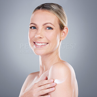 Buy stock photo Happy woman, portrait and cream with shoulder for skincare or moisturizer on a gray studio background. Young female person or model with smile for anti aging treatment, lotion or cosmetic ointment