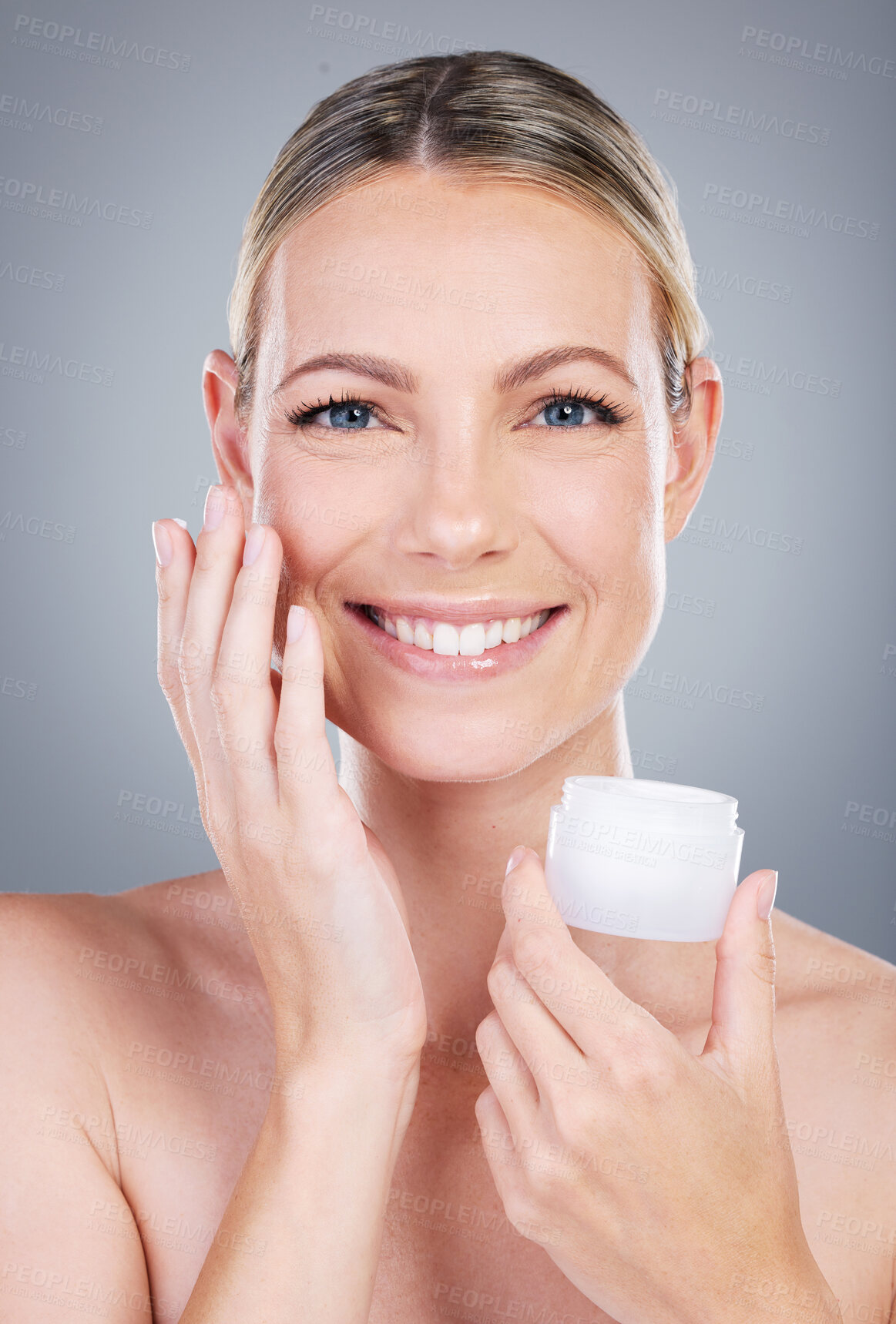 Buy stock photo Happy woman, portrait and face cream with container in skincare or moisturizer on a gray studio background. Young female person or model with smile for facial ointment, lotion or anti aging cosmetics