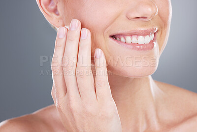 Buy stock photo Studio shot of an unrecognisable woman applying moisturiser on her face against a grey background