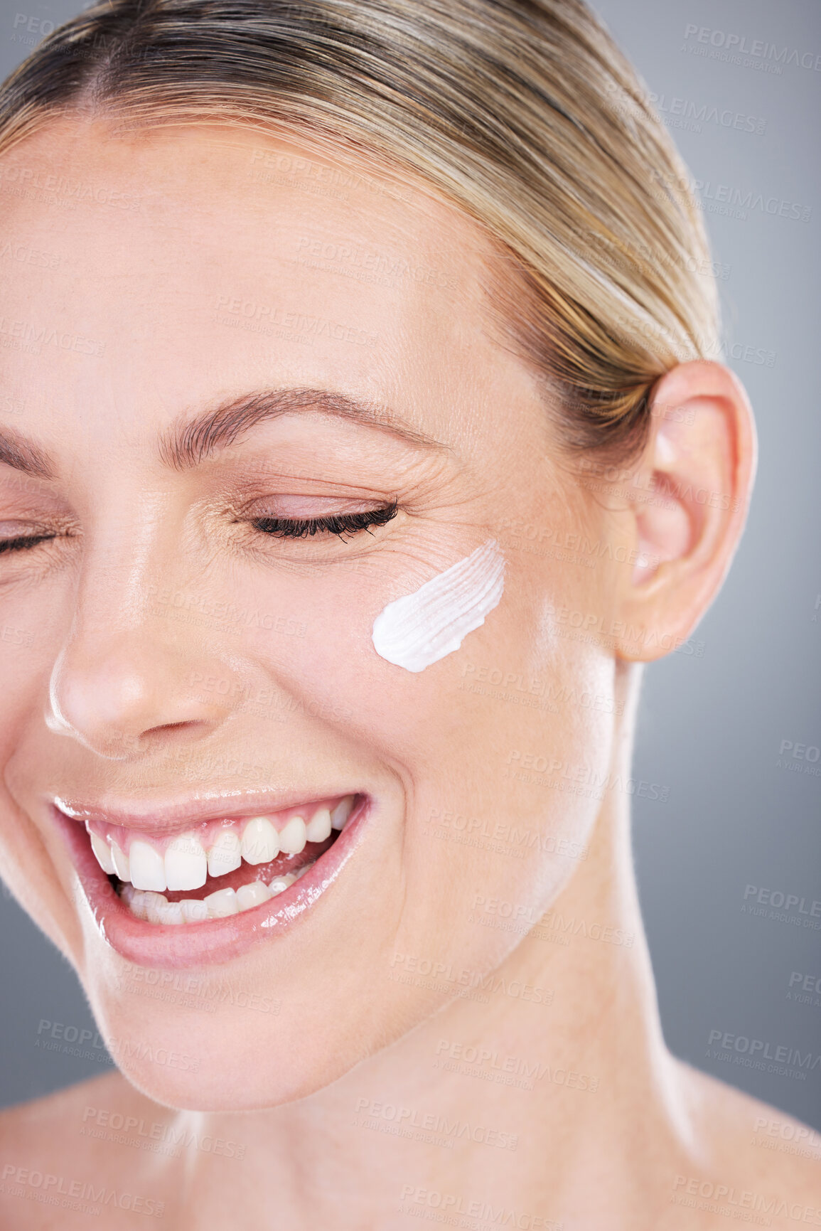 Buy stock photo Studio shot of an attractive mature woman applying moisturiser on her face against a grey background