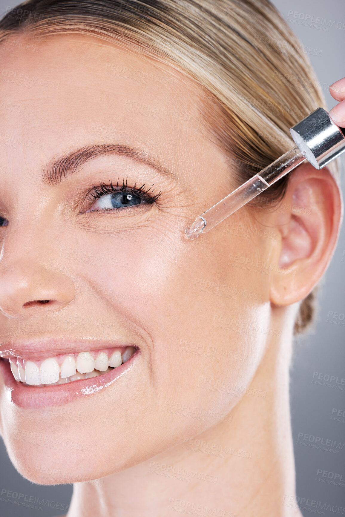 Buy stock photo Happy woman, portrait and dropper with serum for skincare, oil or vitamin C on a gray studio background. Closeup of young female person or model with smile or pipette for facial treatment or collagen