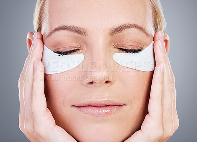 Buy stock photo Studio shot of an attractive mature woman wearing under eye patches against a grey background