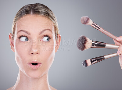 Buy stock photo Studio shot of an attractive mature looking surprised while woman holding a collection of makeup brushes against a grey background