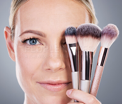 Buy stock photo Makeup brushes, smile and portrait of woman in studio with foundation routine for clear skin. Cosmetic, glow and female person with beauty tools for face cosmetology treatment by gray background.