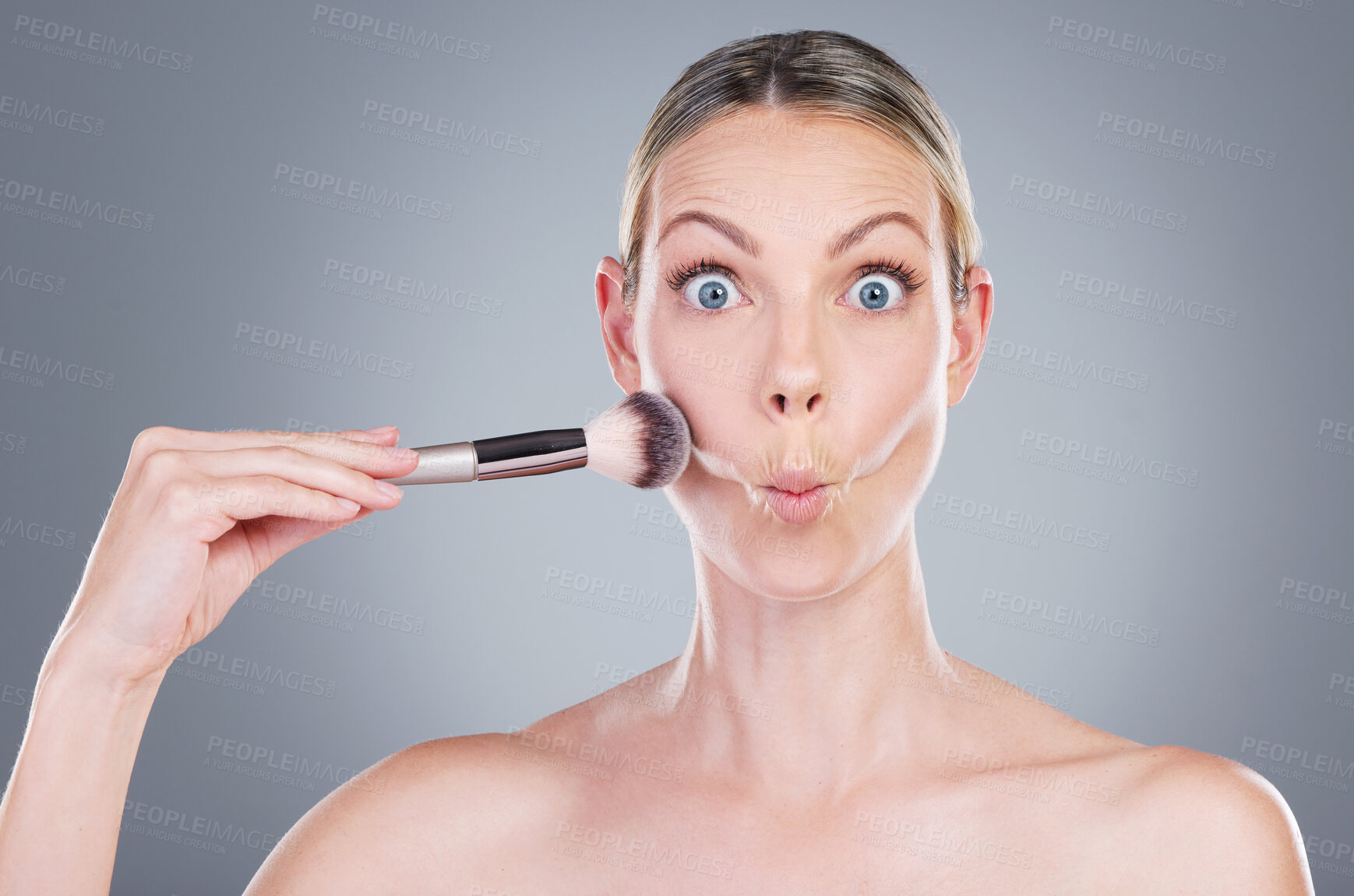 Buy stock photo Makeup brush, portrait and woman with fish face in studio for blush application with makeover. Cosmetic, goofy and female person with beauty tool for facial cosmetology treatment by gray background,