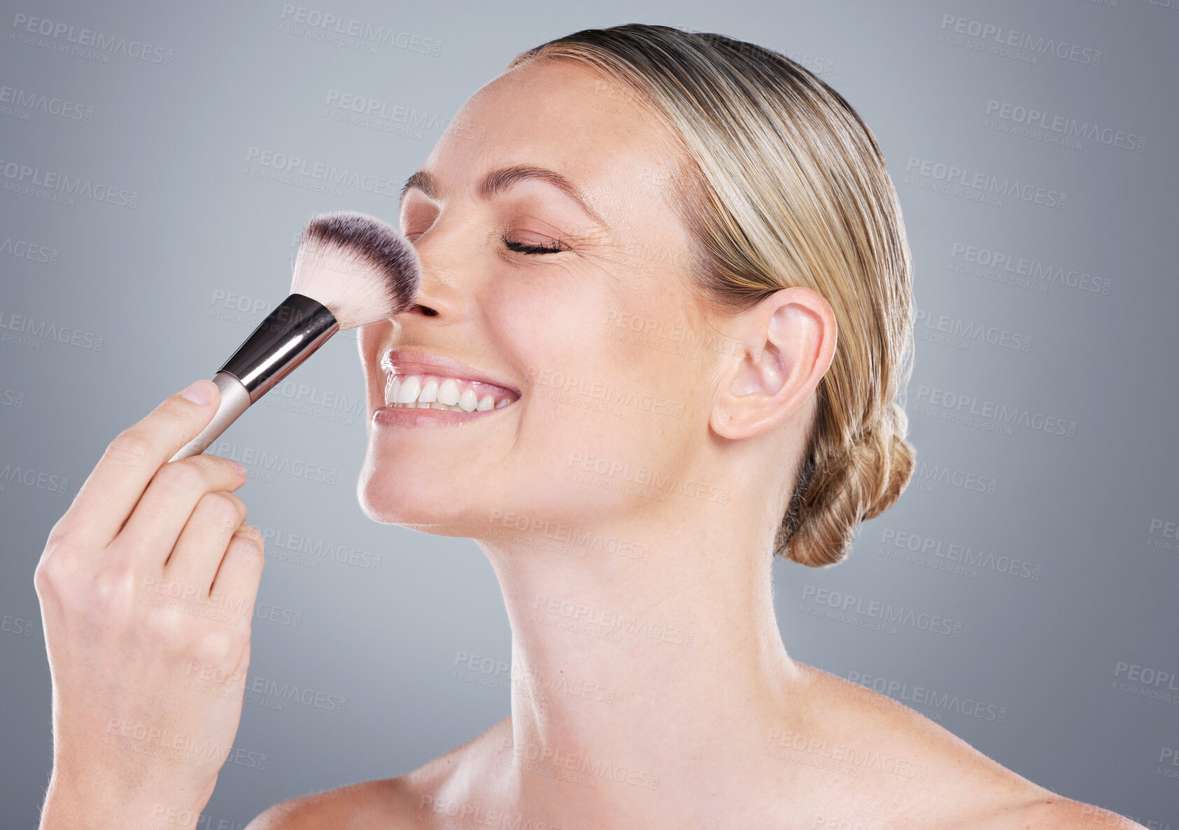 Buy stock photo Makeup brush, smile and woman in studio with self care foundation routine for clear skin. Cosmetic, makeover and female person with beauty tool for face cosmetology treatment by gray background.