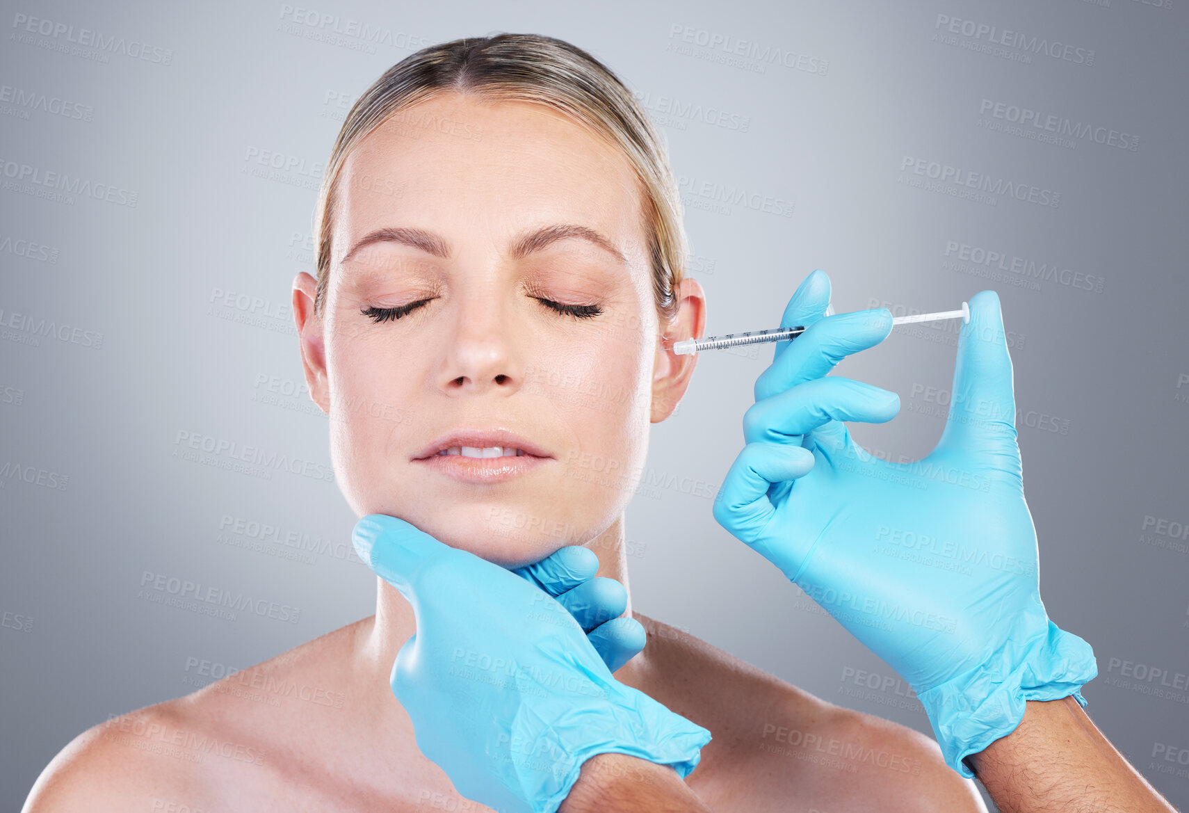 Buy stock photo Face, woman and hands in studio with injection, medicine and collagen filler for facial treatment. Dermatology, female person and doctor with syringe for numb skin, plastic surgery or gray background