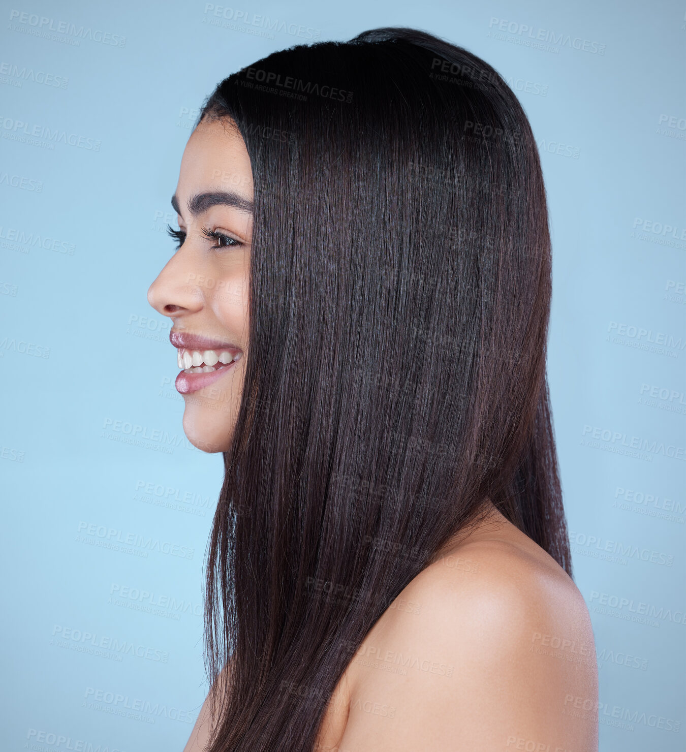 Buy stock photo Studio shot of a beautiful young woman showing off her long silky hair against a blue background