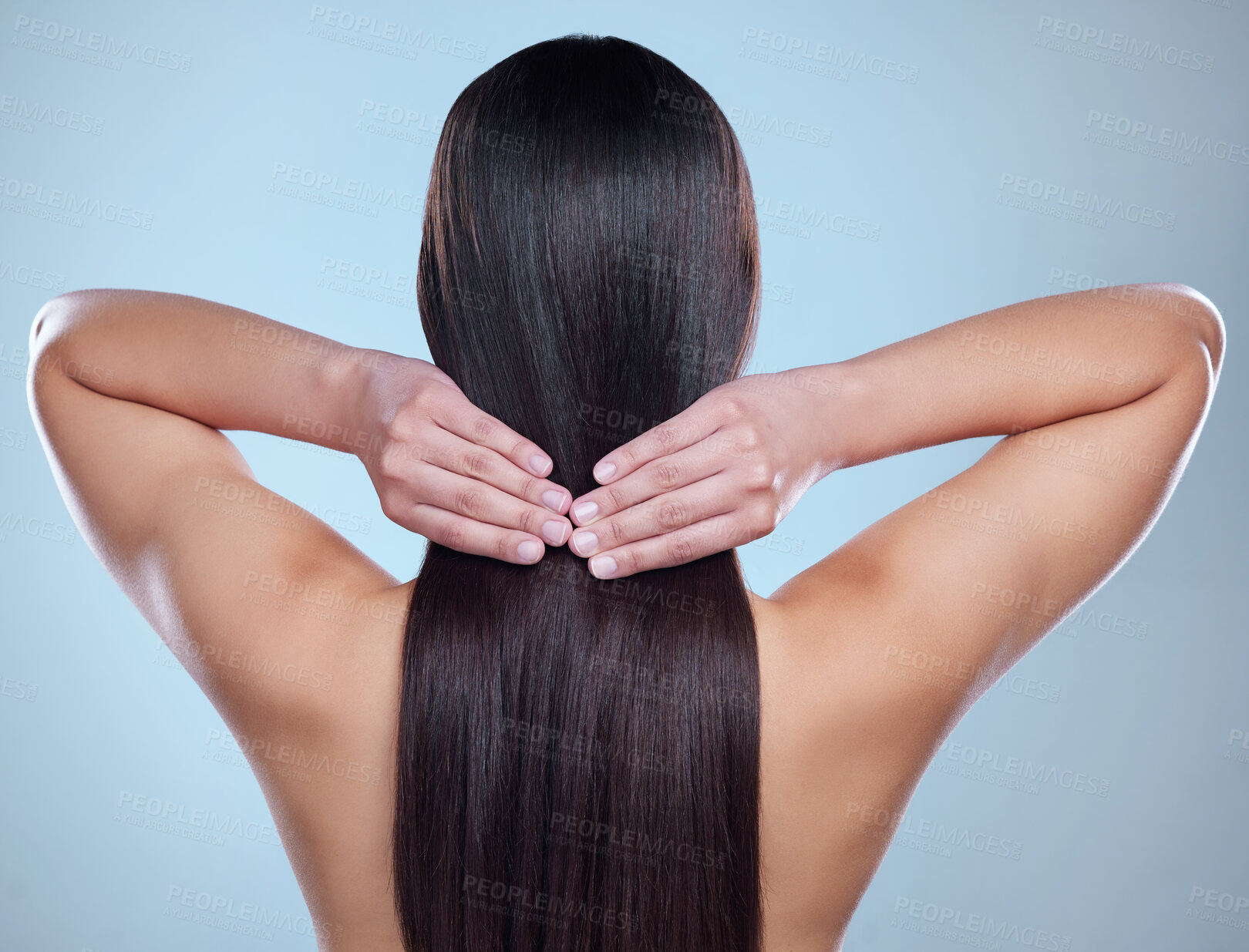 Buy stock photo Rearview studio shot of an unrecognizable woman with beautiful silky hair posing against a blue background