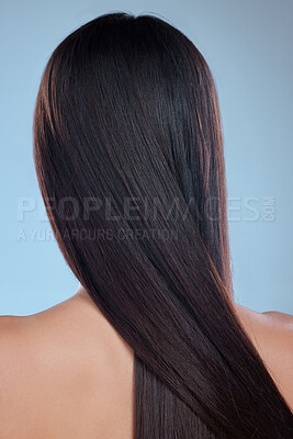 Buy stock photo Rearview studio shot of an unrecognizable woman with beautiful silky hair posing against a blue background