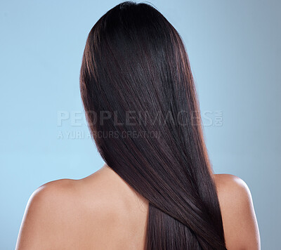 Buy stock photo Rearview studio shot of an unrecognizable woman with beautiful silky hair posing against a blue background