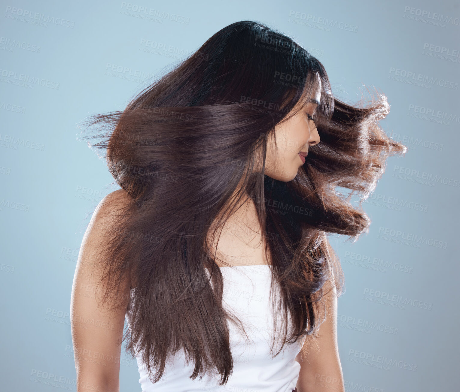 Buy stock photo Hair toss, woman and beauty in studio for shine, growth and salon treatment. Female person, confidence or luxury care on blue background for aesthetic, shaking head or keratin glow for smooth texture