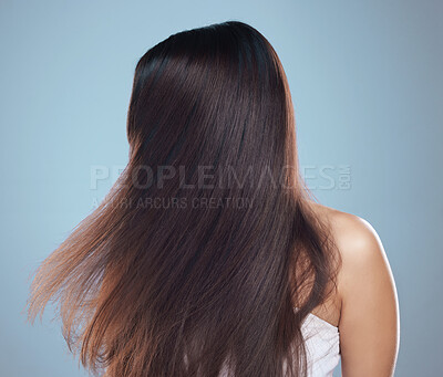 Buy stock photo Studio shot of an unrecognizable woman with flowing hair against a blue background