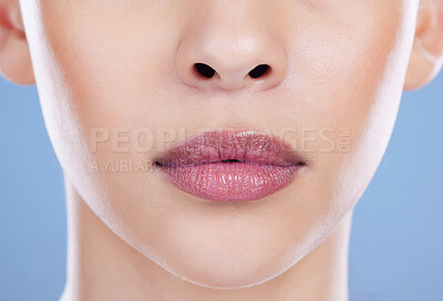 Buy stock photo Woman, beauty and mouth closeup in studio for shine with wellness, lipstick and collagen skincare. Female person, zoom and lip filler for dermatology, healthy glow and isolated by blue background