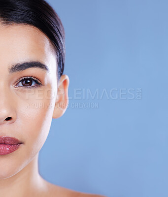 Buy stock photo Cropped shot of a young woman posing alone against a blue background in the studio