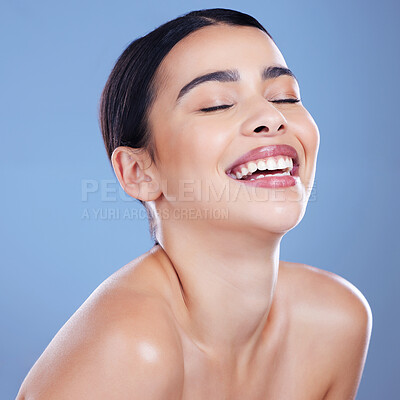 Buy stock photo Shot of an attractive young woman posing alone against a blue background in the studio