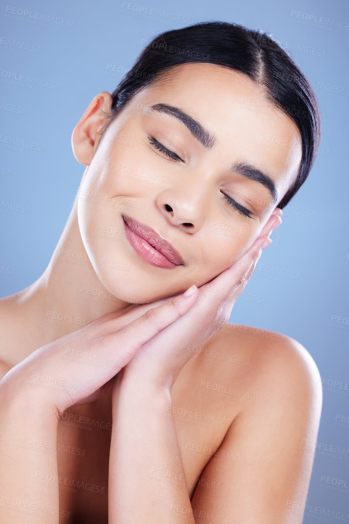 Buy stock photo Shot of an attractive young woman posing alone against a blue background in the studio