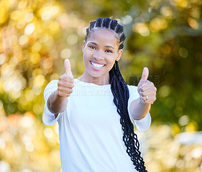 Buy stock photo Shot of a beautiful young woman showing thumbs up while standing outdoors