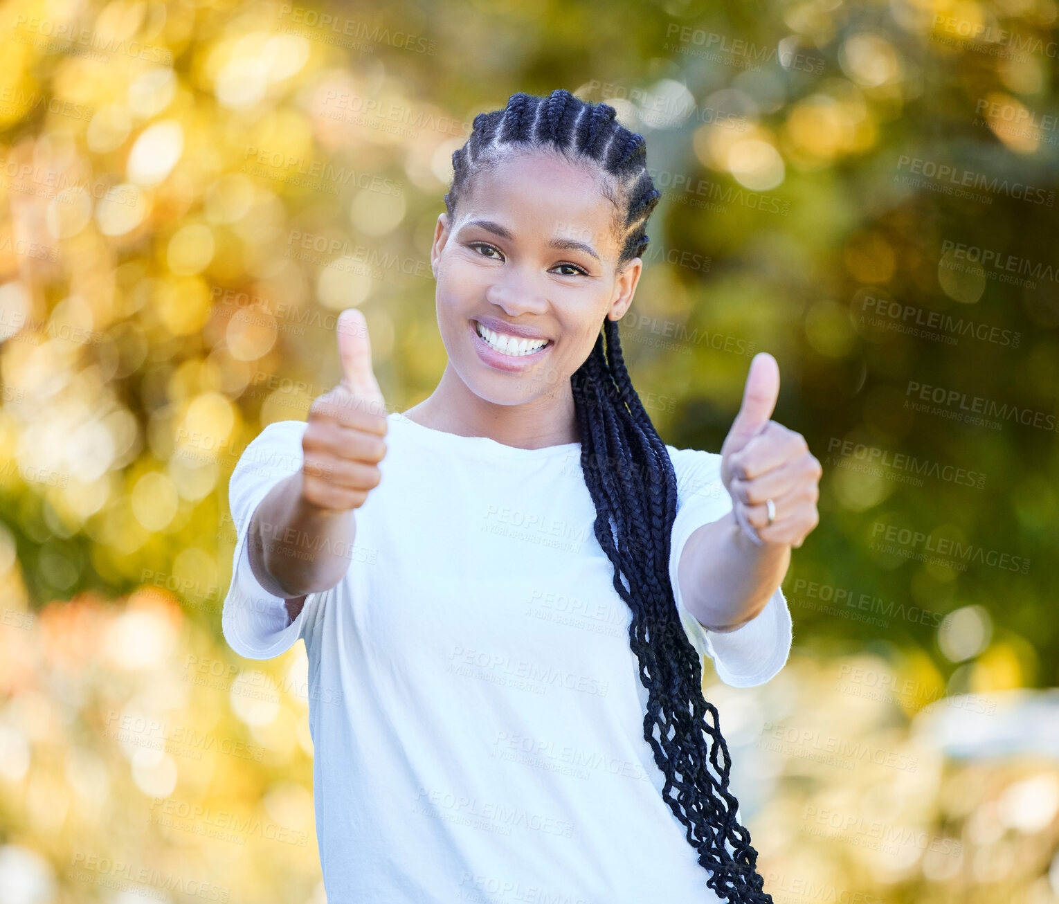 Buy stock photo Shot of a beautiful young woman showing thumbs up while standing outdoors