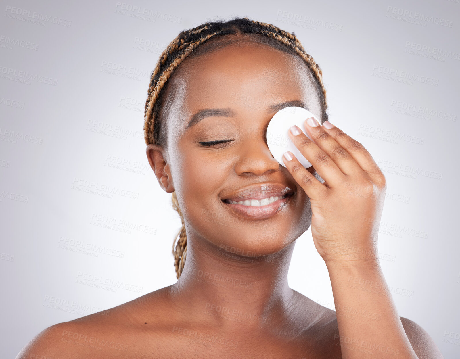 Buy stock photo Cleaning, studio and black woman with skincare on eye for natural beauty, healthy skin or luxury cosmetics on face. Dermatology, smile and happy girl with cotton pad, facial care and white background