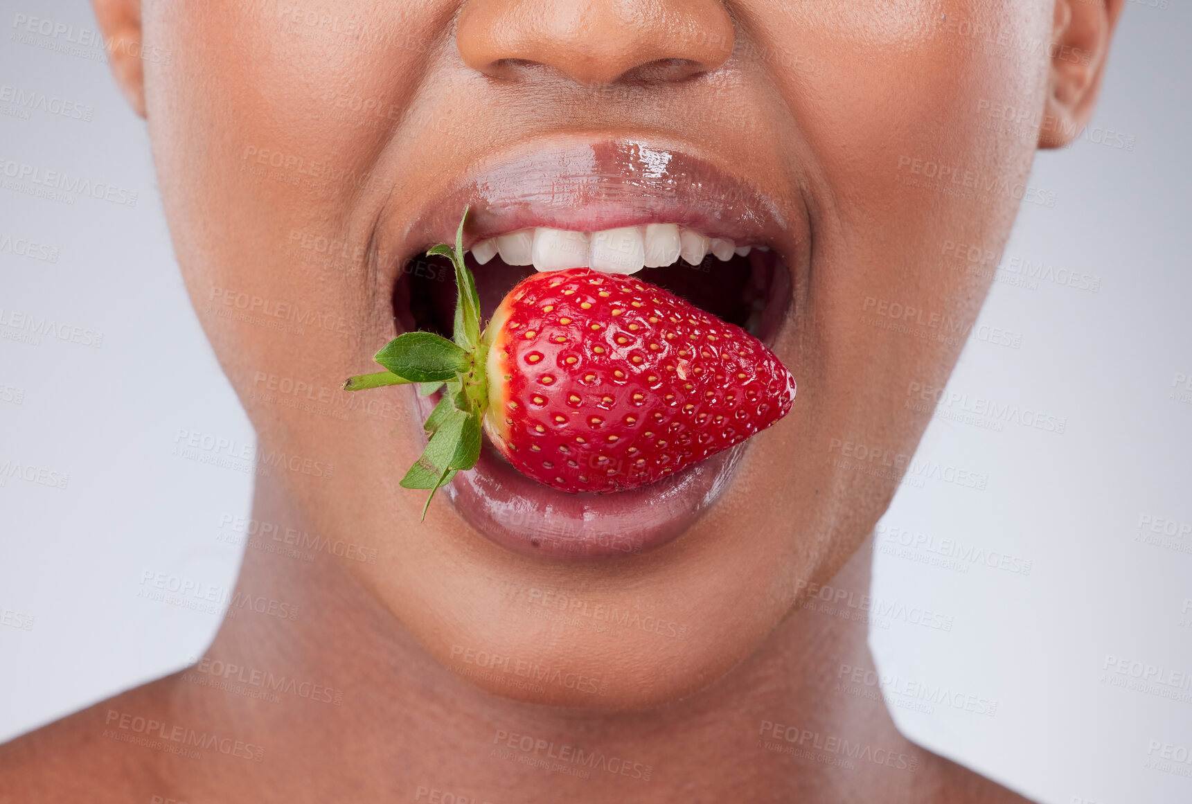 Buy stock photo Black woman, mouth and eating a strawberry in studio for vitamin c, diet and wellness in closeup. Model, bite and hungry for fruit, nutrition and healthy snack with lips or teeth on white background