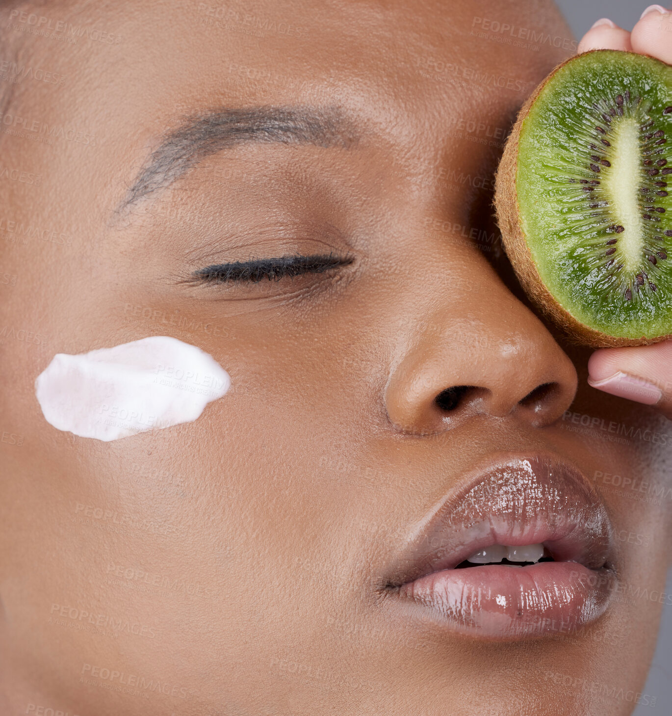 Buy stock photo Face cream, beauty and black woman with kiwi in studio for skincare, wellness and facial mask. Dermatology, fruit and person with moisturizer for vitamin A, health and nutrition on gray background