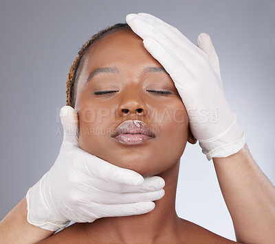 Buy stock photo Plastic surgery, woman and cosmetics with gloves in studio for skincare consultation and routine check for procedure. Black person, expert and facial inspection for face implant on gray background