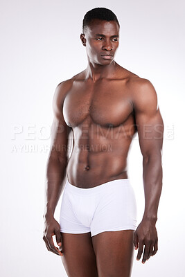 Buy stock photo Shot of a handsome young man posing shirtless against a white background