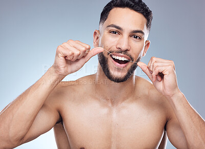 Buy stock photo Man, portrait and flossing teeth in studio for oral hygiene, mouth cleaning and morning routine for tooth care. Dental, person and thread for fresh breath, plaque and healthy gyms on gray background