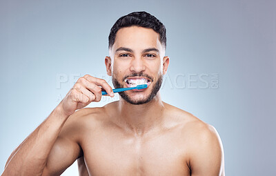 Buy stock photo Man, portrait and happy with brushing teeth in studio for oral hygiene, mouth cleaning and morning routine. Mockup, person and toothbrush for fresh breath, dental and healthy gums on gray background