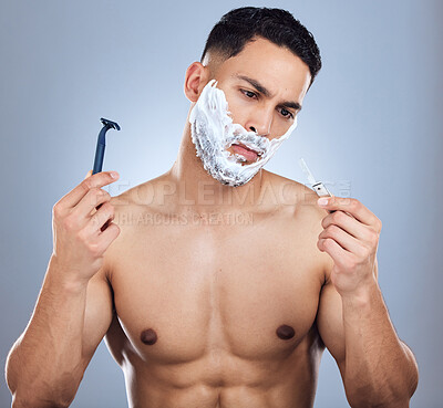 Buy stock photo Man, shaving and choice for razor in studio with skincare and confused for face transformation tools. Male person, doubt and decision for blade product with hair removal and beard by gray background