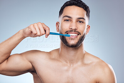 Buy stock photo Man, portrait and happy with brushing teeth in studio for oral hygiene, mouth cleaning and morning routine. Dental, person and toothbrush for fresh breath, plaque and healthy gums on gray background